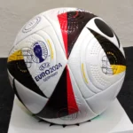 Adidas Fussballliebe Euro 2024 soccer ball featuring white, black, and glow blue colors with bold graphics inspired by European football, designed for precision and control.